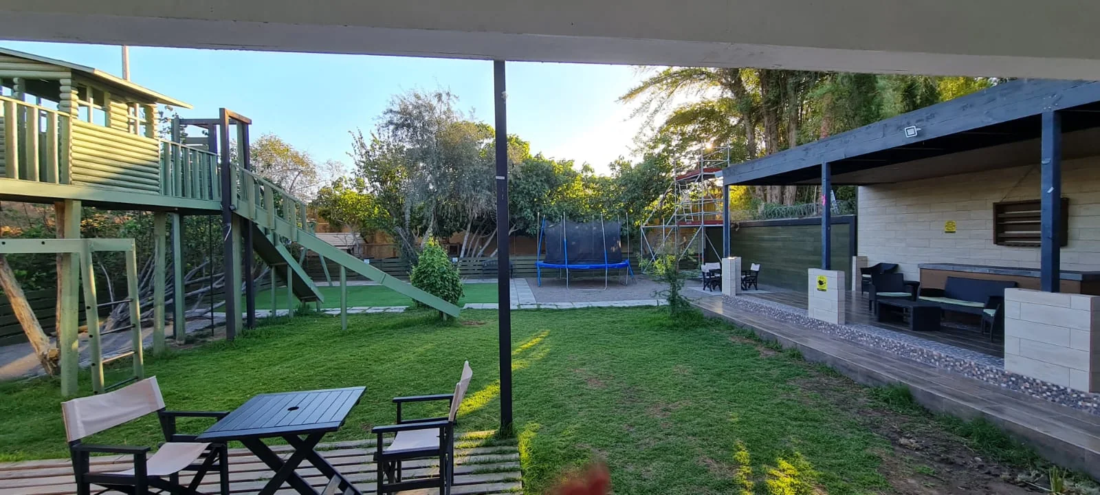 Patio con juegos infantiles y cama elástica